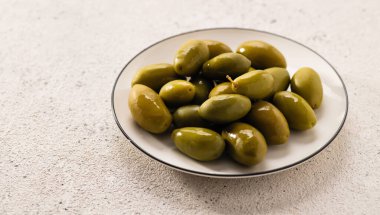 Tabakta büyük yeşil zeytinler, açık arkaplan, yakın plan