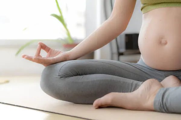 Güzel, hamile bir kadın meditasyon ve yoga egzersizleri yapıyor.