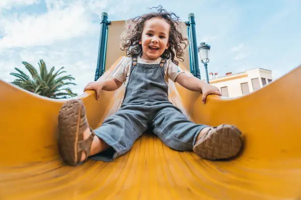 Retrato Menino Feliz Saltando Para Baixo Uma Corrediça Amarela Playground — Fotografia de Stock