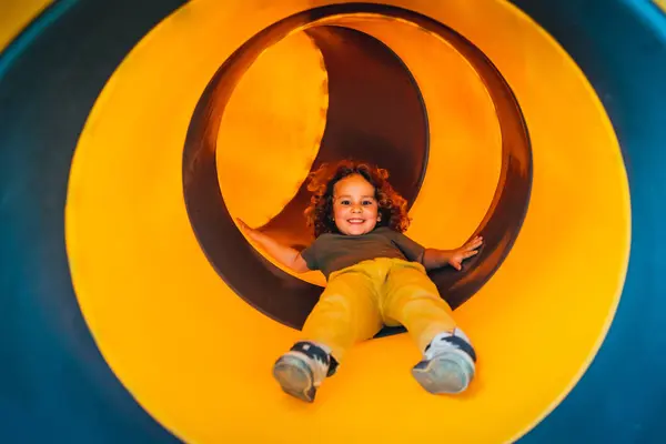 Retrato Menino Feliz Saltando Para Baixo Uma Corrediça Amarela Playground — Fotografia de Stock