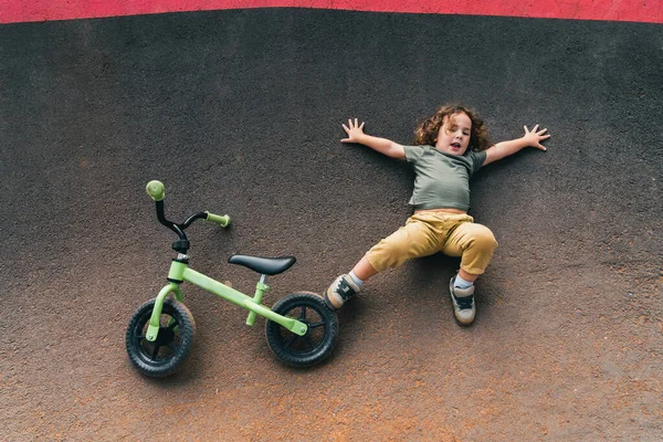 Mutlu Küçük Çocuk Bisikleti Pompa Pistinin Asfaltında Yatıyor — Stok fotoğraf