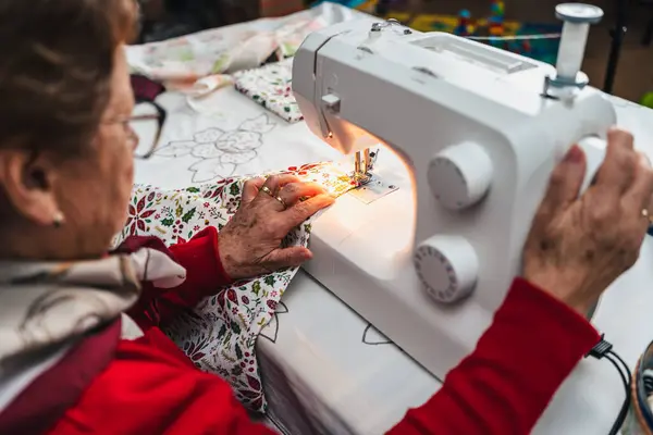 Kırmızılı Yaşlı Kadın Dikiş Makinesiyle Elbise Dikiyor — Stok fotoğraf