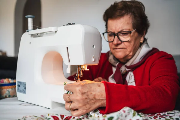 Dikiş Makinesine Gözlük Takan Kırmızılı Yaşlı Kadın — Stok fotoğraf