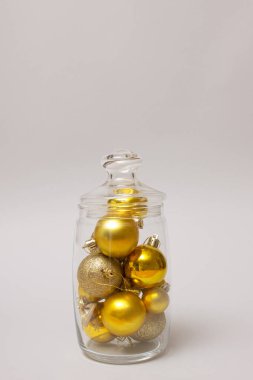 Cam kasede Noel süsü. Çeşitli dokularda Noel ağacı için sade altın, mat, parlak, parlak ve gümüş süsleme topları. Yemek kavanozu ünlü yeni yıl tatili hediyeleriyle dolu..