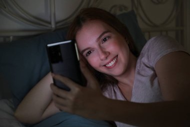 Ergen, yatmadan önce akıllı telefonuyla video görüşmesi yapıyor.