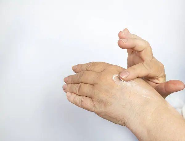 Yakın plan. Eline krem sürerken günlük rutinini yapan olgun, orta yaşlı bir kadın. Yaşlanma önleyici cilt bakımı. Spa tedavileri