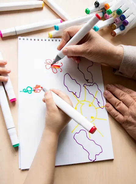 Renkli keçeli kalemler ve keçeli kalemlerle küçük çocukların ve öğretmenlerin çizimlerinin ayrıntıları