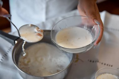 Kadın bir kaseye doğranmış incir, şeker ve ılık koyun sütü döker. Otantik kadın elleri geleneksel bir albanya tarifi hazırlıyor, Osmanlı.