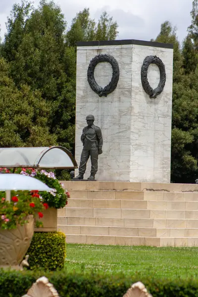 Çok doğal toprakları olan bir anıtın yanındaki asker heykeli.