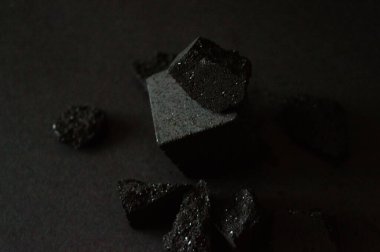 Siyah arka planda nargile için bir yığın kömür. Hasarlı kömür küpü. Mesaj için yer var. Yumuşak odaklanma. Marka tasarımlarınız ve reklamlarınız için fotoğraf. Bulanık resim