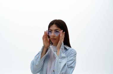 Görme yeteneği zayıf olan bir doğu kadını görme yetisini, optik konseptini ve gözlük seçimini odaklamak için gözlerini kısar. İzole edilmiş.