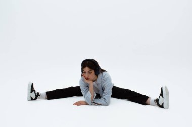 Üzgün görünümlü genç bir kız sıkılıyor. Moda kıyafetleri içinde oturuyor. Mesaj için yer var. Müzik dinliyormuş. Üzüntü ve yalnızlık.