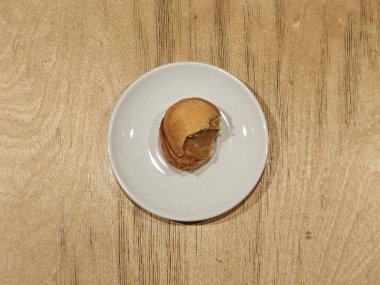 Ahşap masanın üzerinde kaynatılmış konsantre sütle ceviz şeklinde kurabiyeler. Beyaz tabak. Mesaj için yer var. Kafe ya da restoran reklamı. Dizinin bir parçası.