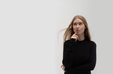 Dalgın, güzel, genç, sarışın Ukraynalı kız çenesine dokunuyor, fotokopi odasına bakıyor, şüpheleri var, bir şeylerden şüpheleniyor. İzole edilmiş. Dizinin bir parçası. Tasarım için pankart.