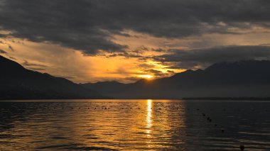 Kırmızı, mor, turuncu renklerle gölde muhteşem bir gün batımı.