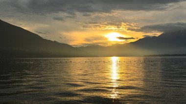 Kırmızı, mor, turuncu renklerle gölde muhteşem bir gün batımı.