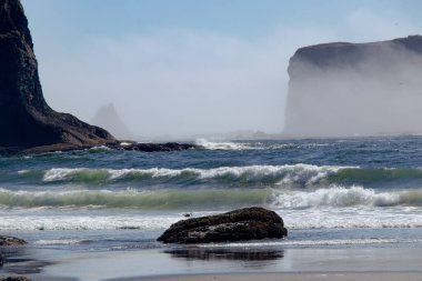 Güneşli bir günde, sabah ışığında kumsalda dalgalar.