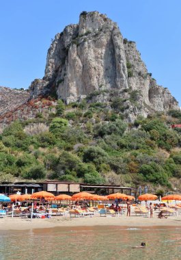 Sperlonga, Lazio, İtalya 5 Eylül 2021: Baia delle Sirene plajı Roccia dei Falchi 'nin egemenliğinde