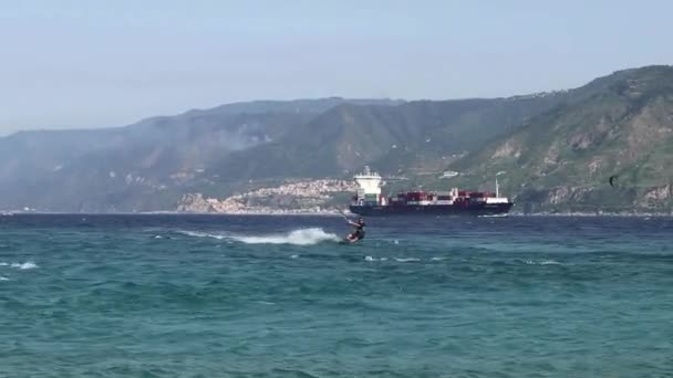 メッシーナ シチリア島 イタリア8月30 2020 貨物コンテナ船が通過するとしてメッシーナ海峡のカイトサーファー — ストック動画