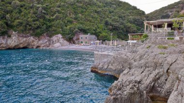 Marina del Cantone - 4 Eylül 2023: Conca del Sogno restoranı, bitişik otel ve lidoyla, günbatımında Recommone Körfezi 'nde.