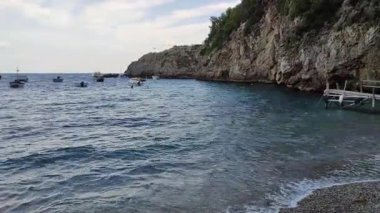 Marina del Cantone - 4 Eylül 2023: Conca del Sogno restoranı, bitişik otel ve lidoyla günbatımında Recommone Körfezi 'nde
