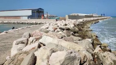 Termoli, Molise, İtalya 12 Nisan 2024: Viale dei Trabucchi 'den deniz fenerine ulaşan dalgakıran boyunca liman gezisi