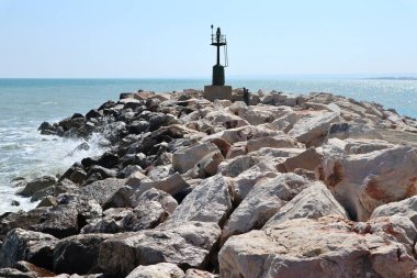 Termoli, Molise, Italy  12 April 2024: Promenade of the Port along the breakwater that from Viale dei Trabucchi reaches the lighthouse clipart
