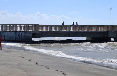 Lido di Ostia, Lazio, Italy - May 3, 2024: Ostia pier in Piazza dei Ravennati with rough sea clipart