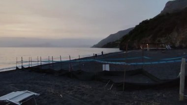 Maratea, Basilicata, İtalya - 22 Eylül 2023: Cala Jannita 'da Scoglio SantJanni' nin önünde Black Beach