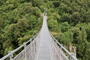 Laviano, Campania, Italy  June 24, 2023: Tibetan Bridge, opened to the public in 2015, which from the Rupe dellOlivella, near the Norman Castle, crosses the Vallone delle Conche at a height of about 90 meters from the ground clipart