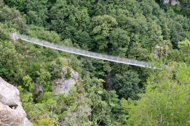 Laviano, Campania, Italy  June 24, 2023: Tibetan Bridge, opened to the public in 2015, which from the Rupe dellOlivella, near the Norman Castle, crosses the Vallone delle Conche at a height of about 90 meters from the ground clipart