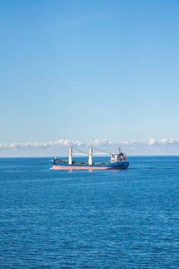 Büyük bir gemi, doğanın güzelliği ile çevrili engin ve geniş bir su kütlesinin yüzeyinde görkemli bir şekilde yüzüyor.