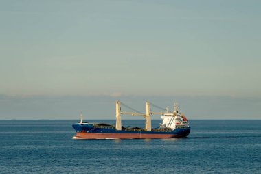 Büyük bir gemi, doğanın güzelliği ile çevrili engin ve geniş bir su kütlesinin yüzeyinde görkemli bir şekilde yüzüyor.