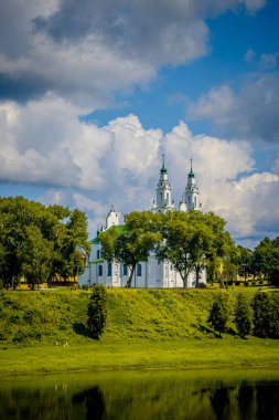 Güzel beyaz bir kilise görkemli bir tepenin üstünde oturur, aşağıdaki sakin göl manzarasını sunar.