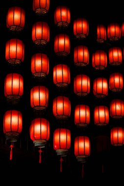 Güzel ve büyüleyici bir kırmızı fener sırası zarif bir şekilde tavandan sarkıyor ve odada çarpıcı bir ortam yaratıyor.