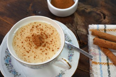 cup of salep with cinnamon powder on the rustic wood background - salep clipart