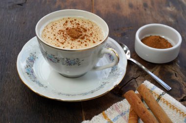 Kırsal ahşap arka planda tarçın tozlu bir fincan salep - salep