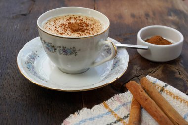 cup of salep with cinnamon powder on the rustic wood background - salep clipart