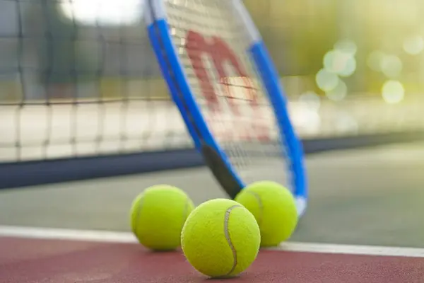 Wilson tenis raketi ve topları sahada                   