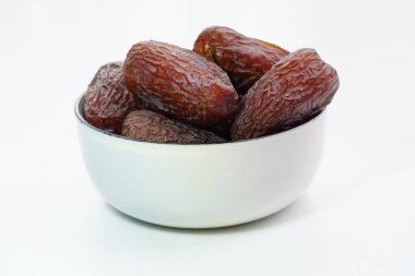 Beyaz arka planda izole edilmiş kasede kurutulmuş tarihler