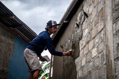 Baubau, Indonesia, June 15 2024 - A craftsman who is renovating a wall - Builder clipart