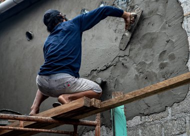 Baubau, Indonesia, June 15 2024 - A craftsman who is renovating a wall - Builder clipart