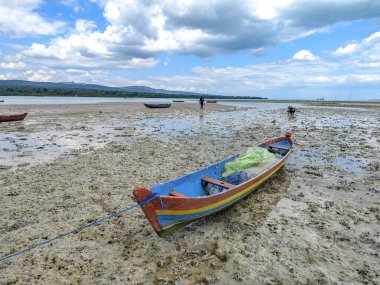 Baubau, Indonesia, November 30, 2024 - Fishing Boats Stranded on Mudflats at Low Tide. clipart