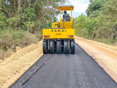 Baubau, Endonezya, 30 Kasım 2024 - Yol Yapımı: Kırsal Bir Bölgede Bir Sakai Pnömatik Tyred Paten Sıkıştırıcı Asfalt.