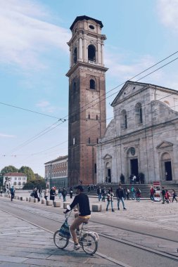 Bisikletli adam 10 Mayıs 2022 'de İtalya' nın tarihi Torino merkezinde yürüyor.