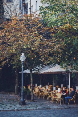 İnsanlar 9 Aralık 2023 'te İspanya' nın Katalonya kentindeki Girona 'nın merkezinde küçük bir terasta dinleniyorlar.