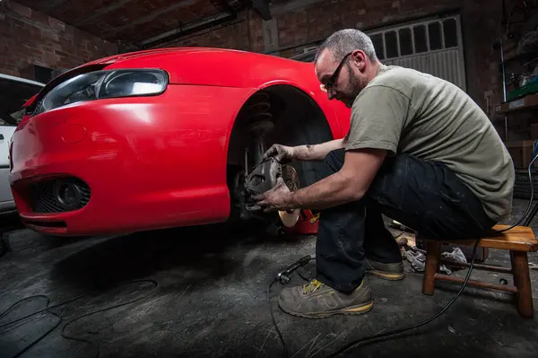Man Diligently Repairing His Car Home Showcasing Hands Automotive Expertise — Stock Photo, Image