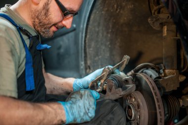 Fren ayarlarına basan bir tamircinin yakın çekimi. Ev mekaniği kavramı.