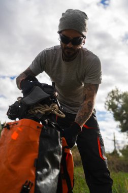 Profesyonel bir ağaç ustası ağaç budama ve bakım işleri için ipini ve teçhizatını hazırlıyor.