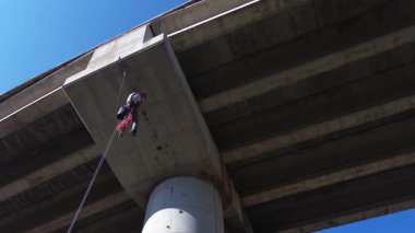 İp erişim teknisyeni yüksek köprü altında teftiş ve bakım yapıyor.
